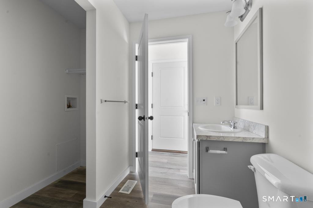 55 Sugar Street, Unit 14 Newtown, CT 06470 - Photo 12 of 18 a bathroom with a granite countertop toilet sink and a mirror