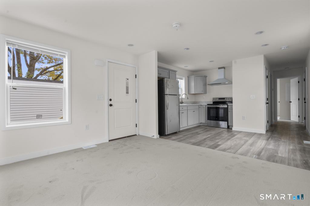 55 Sugar Street, Unit 14 Newtown, CT 06470 - Photo 4 of 18 a view of a kitchen with a stove cabinets and a wooden floor