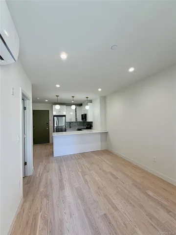 a large kitchen with cabinets wooden floor and stainless steel appliances