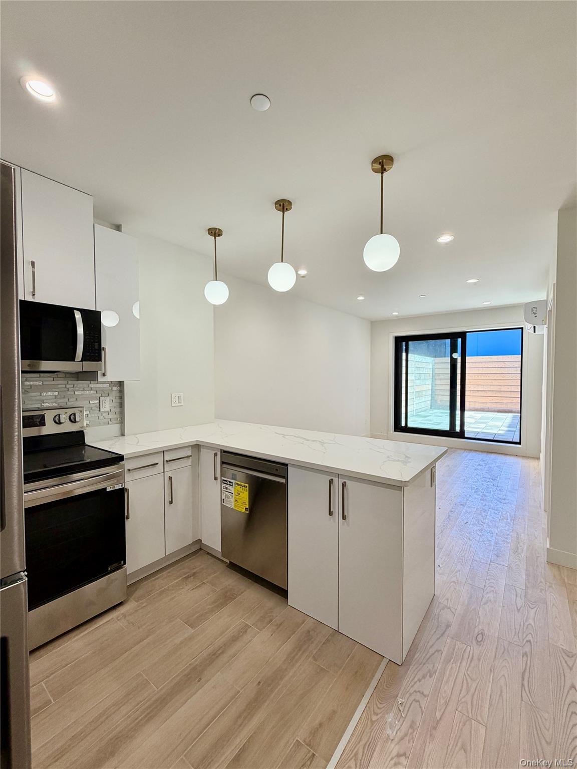 40-09 29th Street, Unit 2F Queens, NY 11101 - Photo 6 of 13 a large kitchen with cabinets wooden floor and stainless steel appliances