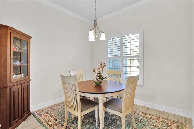 a dining room with furniture a chandelier and wooden floor