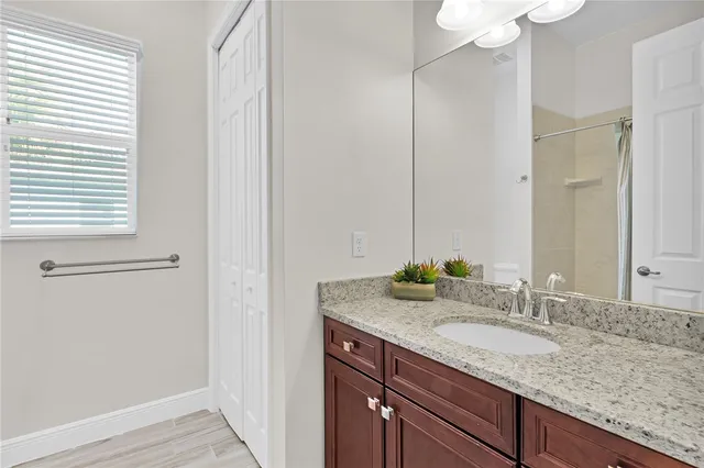 a bathroom with a granite countertop sink and a mirror