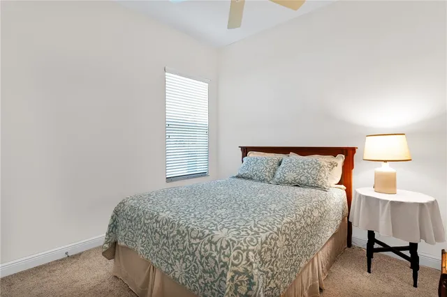 a bedroom with a bed and a lamp on dresser
