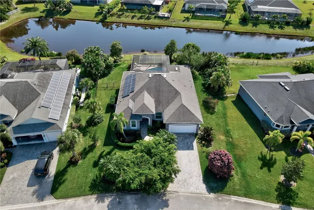 an aerial view of a house with a garden and lake view