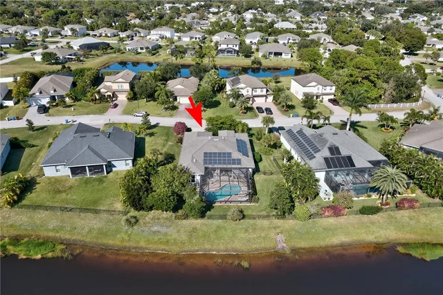 an aerial view of residential houses with outdoor space and parking