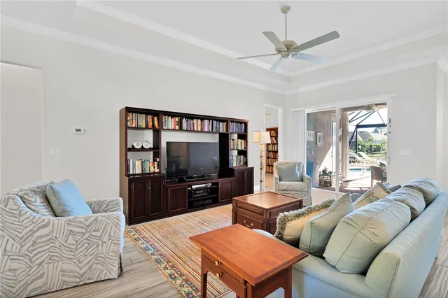 a living room with furniture a ceiling fan and a flat screen tv