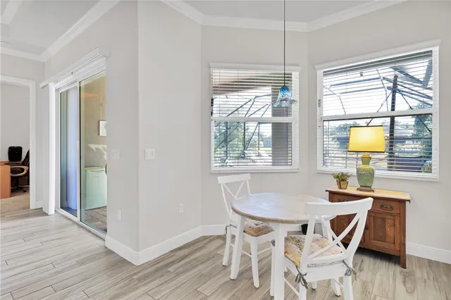 a view of a dining room with furniture a chandelier and wooden floor