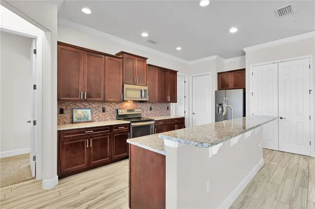 a kitchen with stainless steel appliances granite countertop a sink stove and refrigerator
