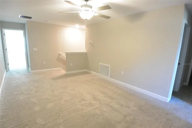 en empty room with windows and fan