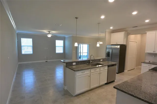 a kitchen with stainless steel appliances granite countertop a sink a stove a refrigerator and a oven