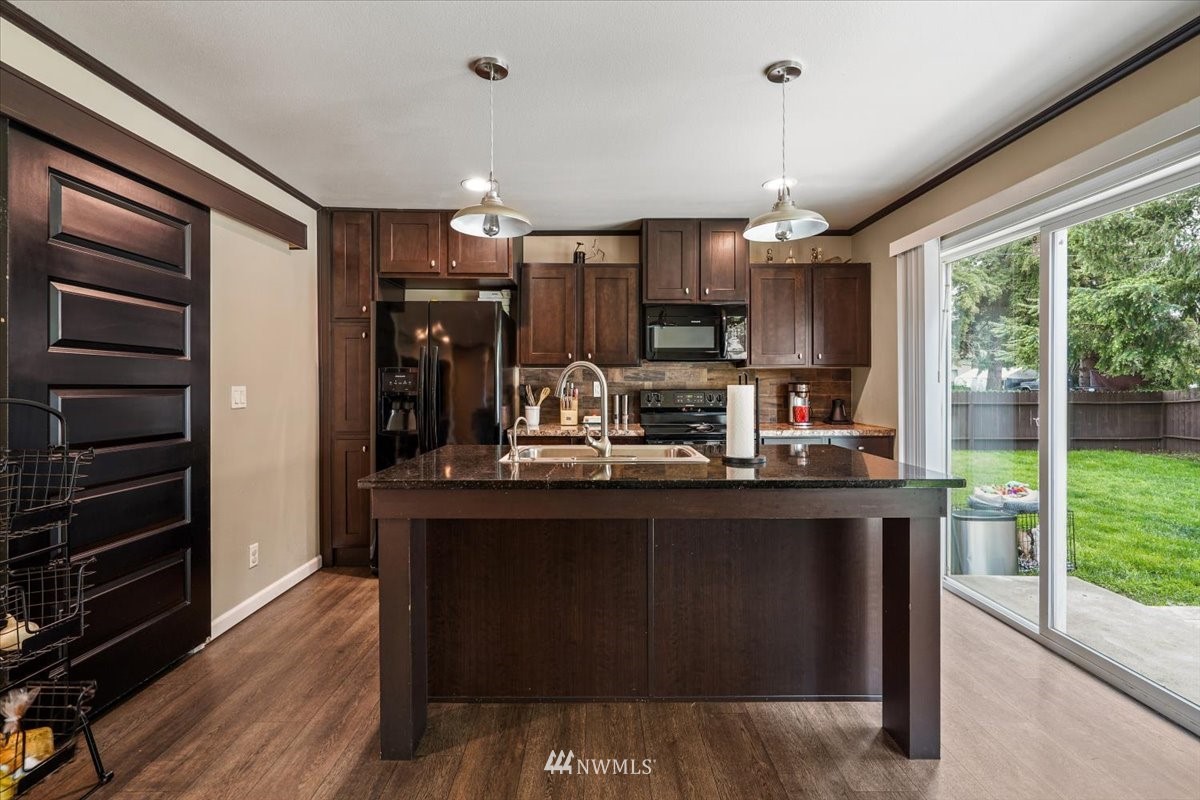 503 Maple Street Pe Ell, WA 98572 - Photo 14 of 27 a kitchen with kitchen island granite countertop a sink cabinets and wooden floor