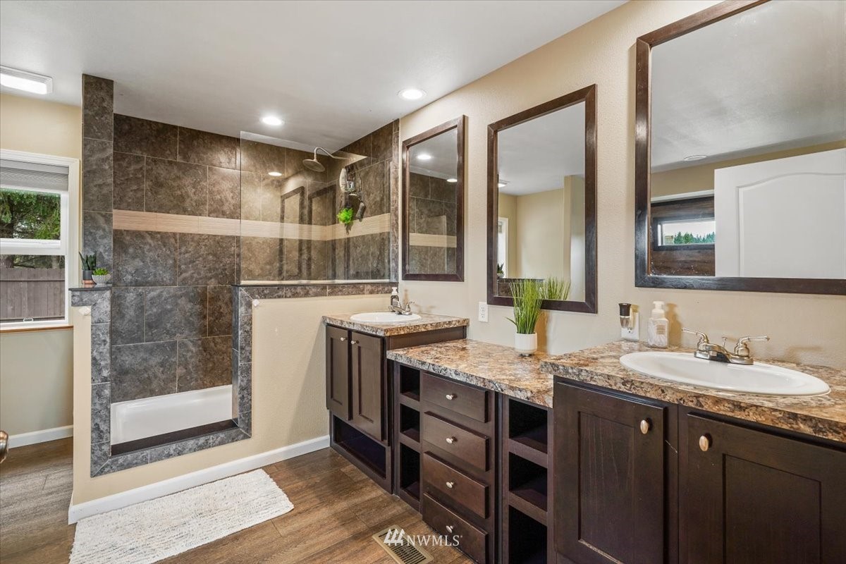 503 Maple Street Pe Ell, WA 98572 - Photo 18 of 27 a bathroom with a granite countertop sink a mirror and a shower