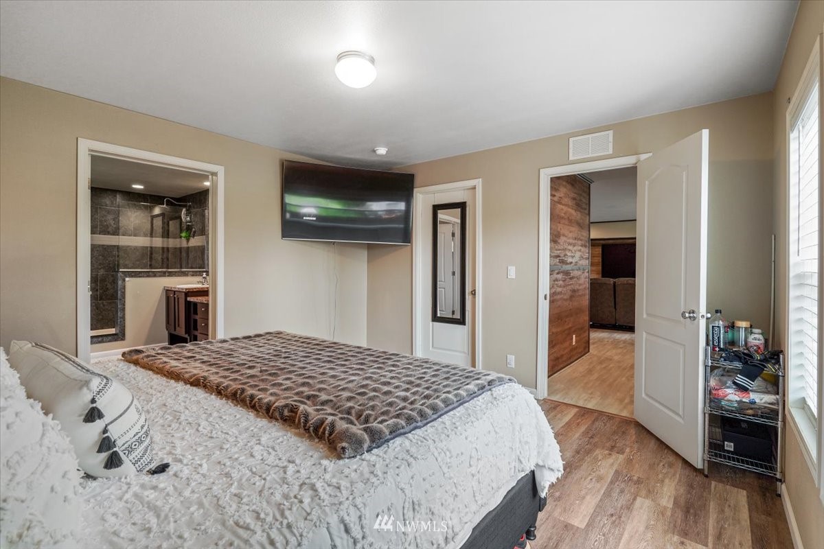 503 Maple Street Pe Ell, WA 98572 - Photo 22 of 27 a bedroom with a large bed a flat tv screen and a dresser