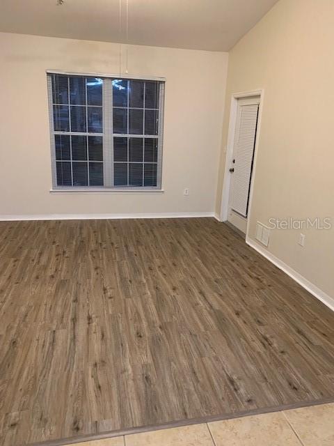 10112 Courtney Palms Boulevard, Unit 201 Tampa, FL 33619 - Photo 12 of 15 an empty room with wooden floor and windows