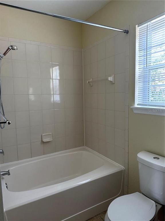 10112 Courtney Palms Boulevard, Unit 201 Tampa, FL 33619 - Photo 13 of 15 a white bath tub sitting next to a toilet