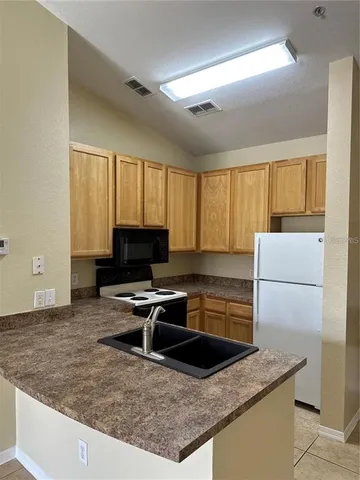 a kitchen with a stove a refrigerator and a microwave