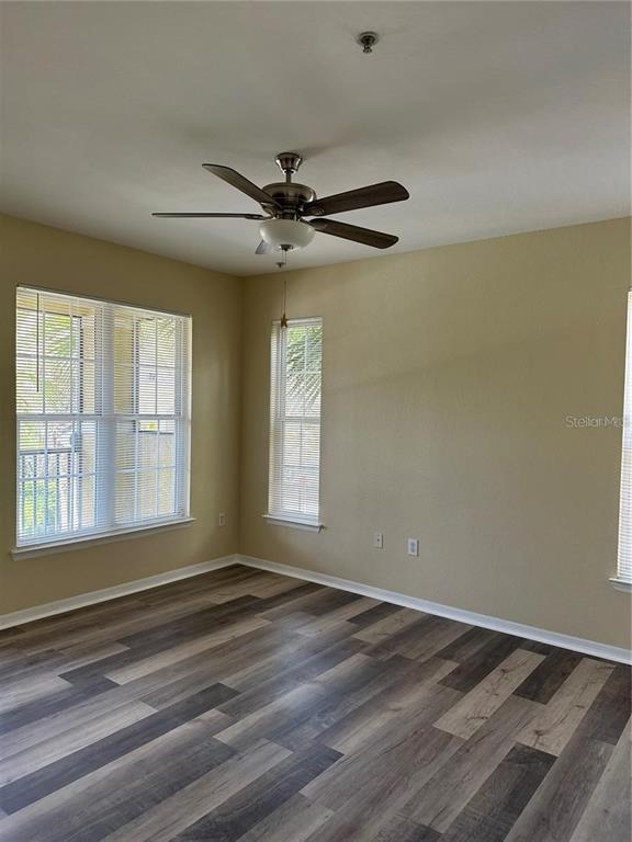 10112 Courtney Palms Boulevard, Unit 201 Tampa, FL 33619 - Photo 9 of 15 a view of empty room with wooden floor and fan