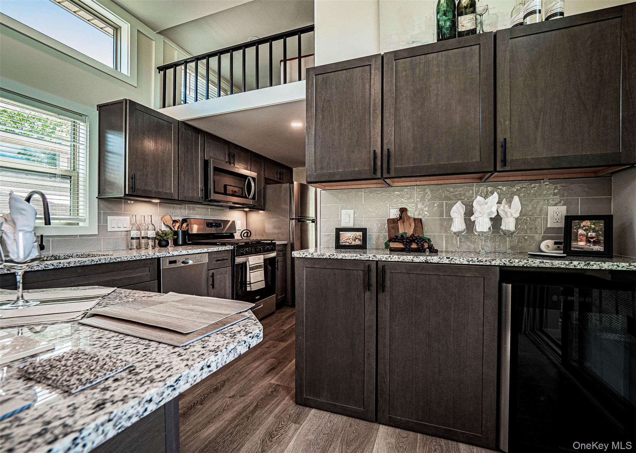 197 Wheeler Road, Unit 91 Florida, NY 10921 - Photo 9 of 48 Kitchen featuring appliances with stainless steel finishes, light stone counters, dark brown cabinetry, and a towering ceiling