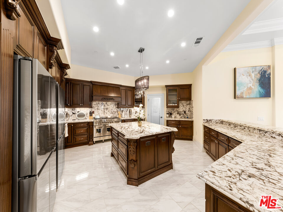 14420 Merlot Court Riverside, CA 92508 - Photo 21 of 57 a kitchen with stainless steel appliances kitchen island granite countertop a stove and a refrigerator