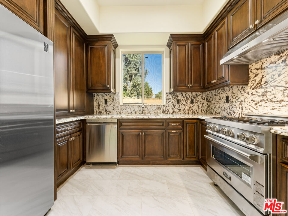 14420 Merlot Court Riverside, CA 92508 - Photo 23 of 57 a kitchen with stainless steel appliances granite countertop a stove and cabinets