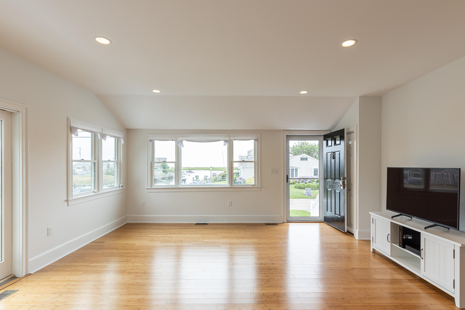 46 Surfside Road West Dennis, MA 02670 - Photo 16 of 32 an empty room with wooden floor and windows