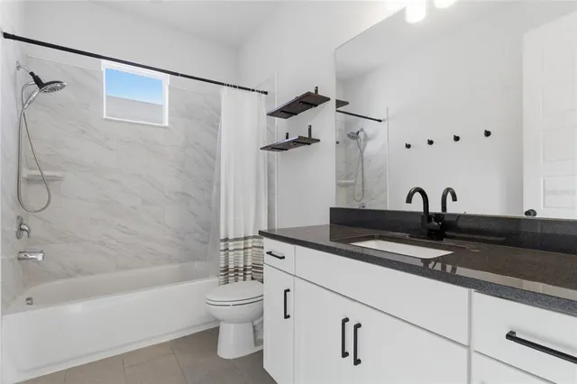 a bathroom with a granite countertop sink a toilet and bathtub