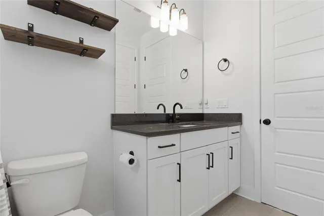 a bathroom with a toilet a sink and mirror