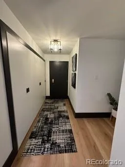 a view of a hallway of a house with wooden floor