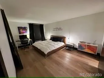 a bedroom with a bed and a flat tv screen on dresser