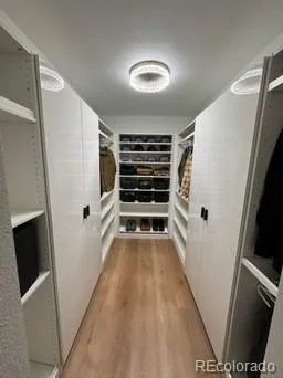 a view of walk in closet with wooden floor and staircase