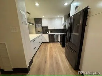 a view of kitchen with refrigerator stove and wooden floor