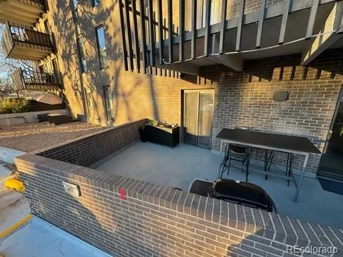 a view of a roof deck with table and chairs a barbeque with wooden floor and fence