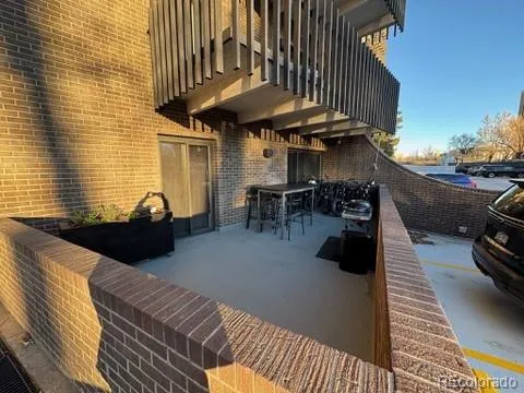 a view of a patio with table and chairs under an umbrella with wooden floor