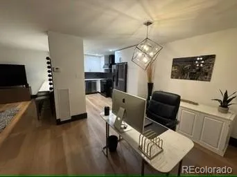 a work room with furniture wooden floor and a flat screen tv