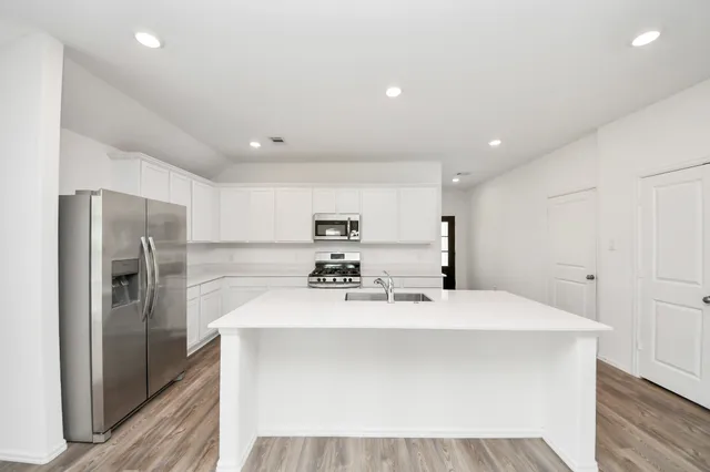 a bathroom with a sink a mirror and refrigerator