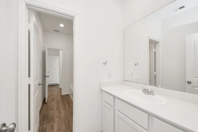 an empty room with wooden floor and a ceiling fan