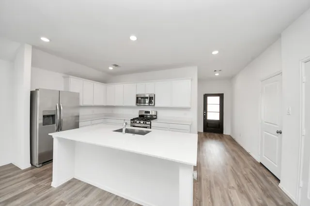 a kitchen with stainless steel appliances a refrigerator sink and stove