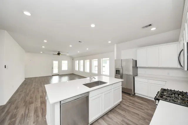 a large kitchen with kitchen island a sink stainless steel appliances and a counter top space