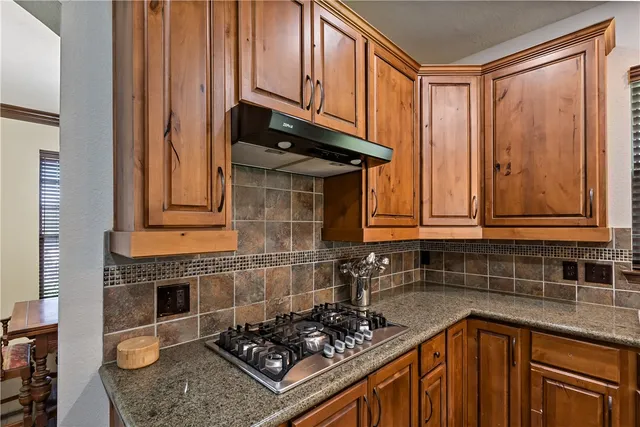 a kitchen with granite countertop cabinets and stove top oven