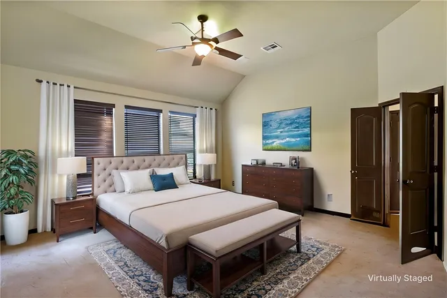 a bedroom with a large bed a chandelier and dresser
