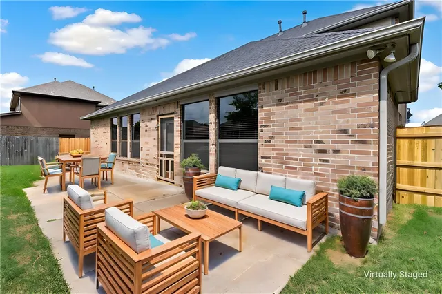 a view of a patio with couches table and chairs with garden view