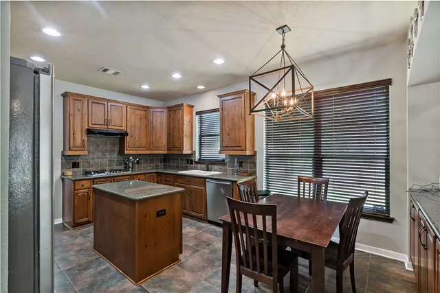a kitchen that has a table chairs in it and wooden floors