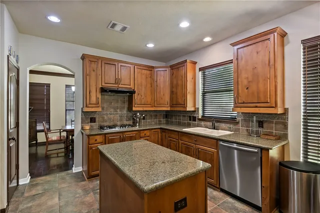 a kitchen with stainless steel appliances granite countertop a sink stove and refrigerator