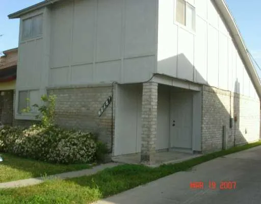 a brick house with a small yard and wooden fence