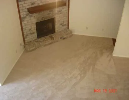 a view of empty room with a fireplace