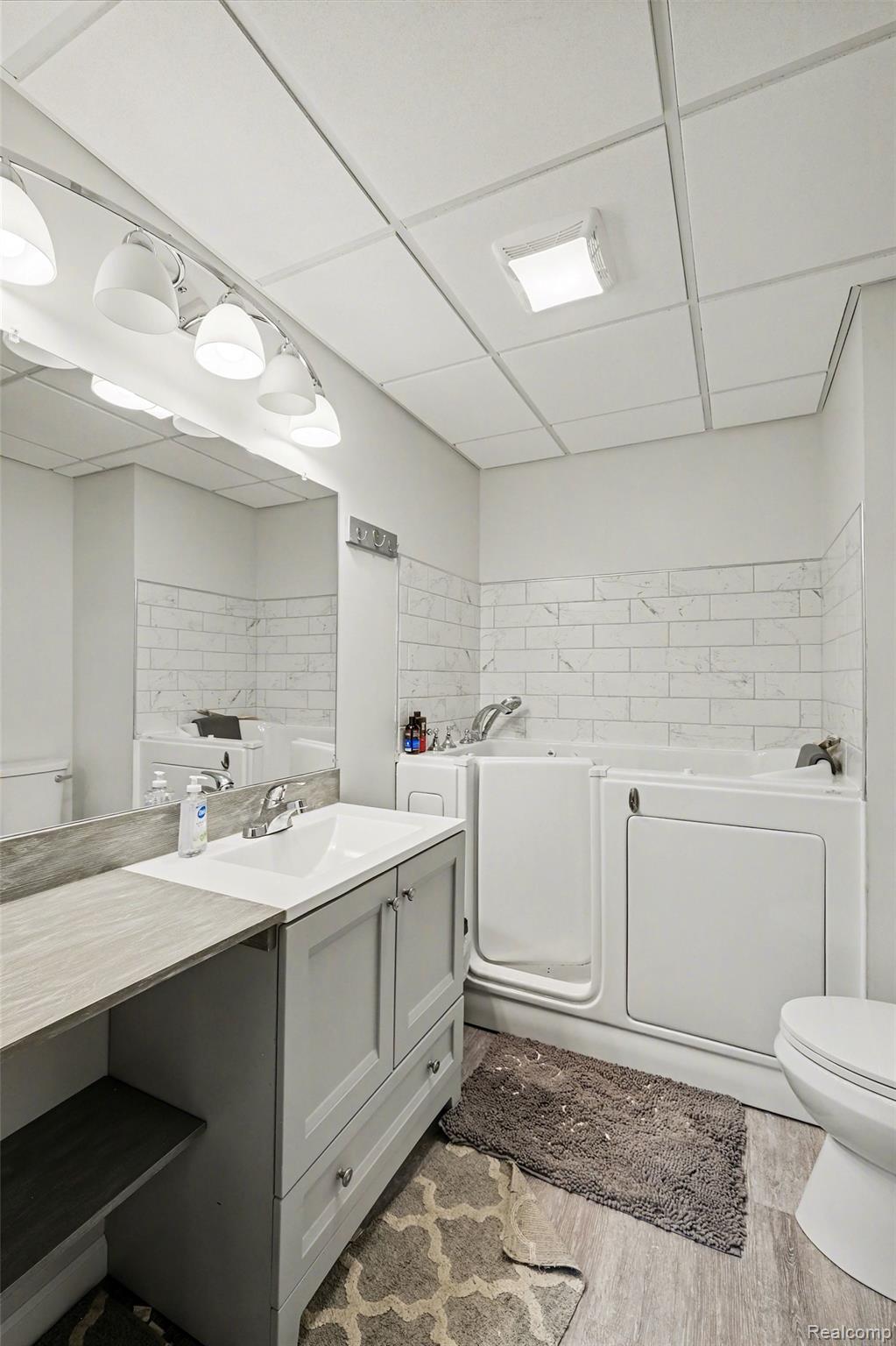 2800 Meadowdale Road Metamora, MI 48455 - Photo 18 of 28 Bathroom with vanity, a drop ceiling, and light wood-style floors