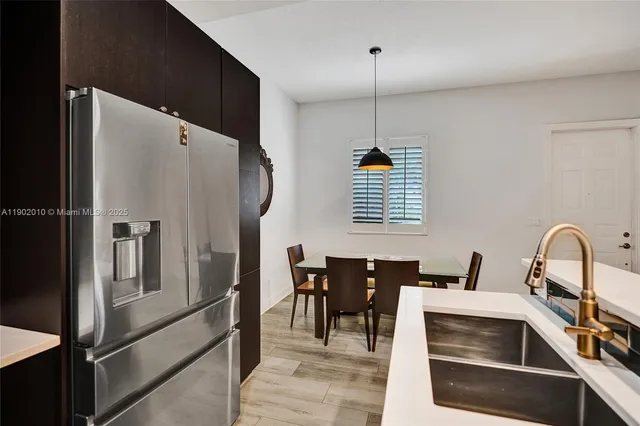 a kitchen with granite countertop a refrigerator stove and sink
