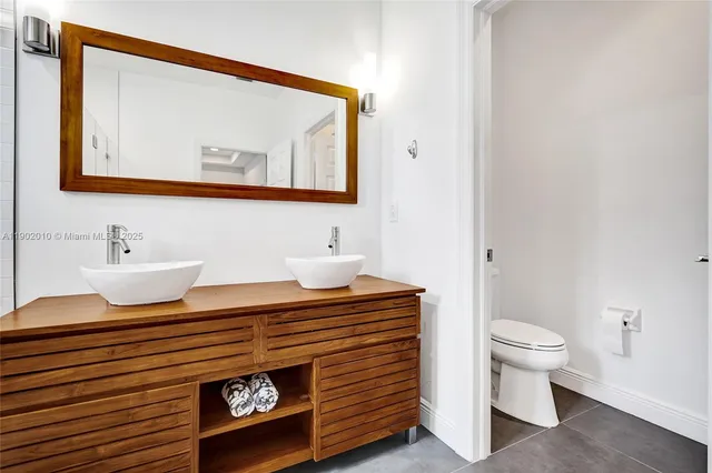 a view of a hallway with wooden floor and a bathroom