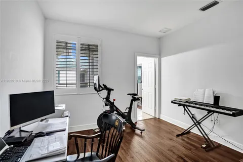 a bedroom with a bed window and a flat screen tv
