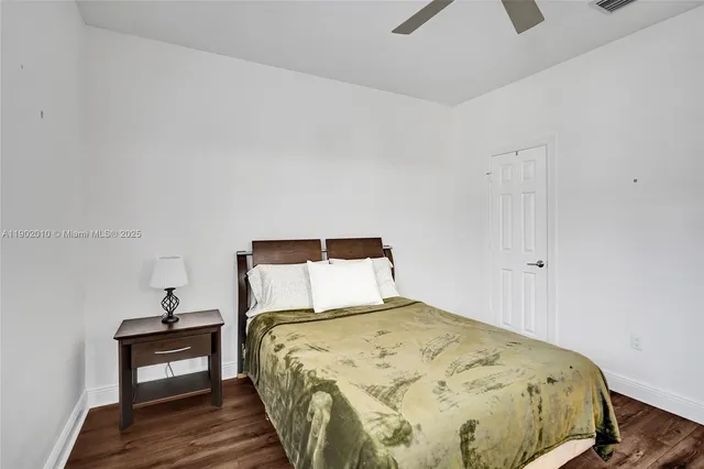 a view of a white house with a large windows and flower plants